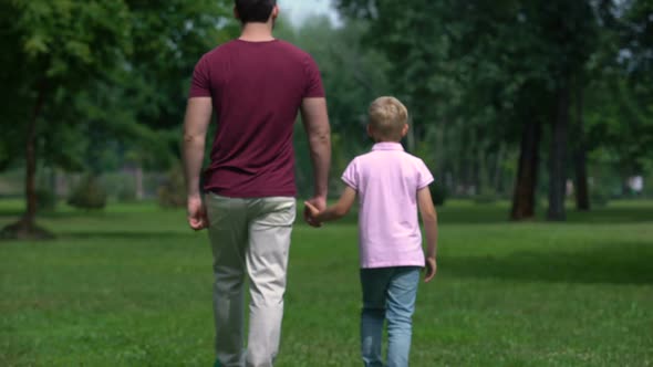 Father and Boy Holding Hands, Walking Away, Giving Advice for Son to Be Real Man