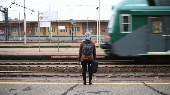 Woman waiting at railroad station platform