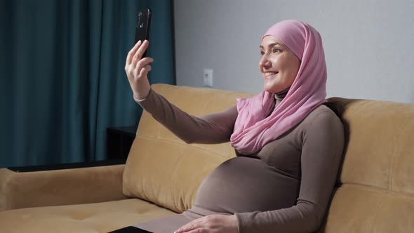 Young Woman Talks Via Videocall Showing Pregnant Belly