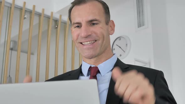 Middle Aged Businessman Celebrating Success Working on Laptop