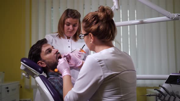 Female Dentist Putting Seal on Patient's Tooth