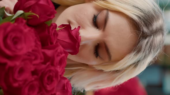 Vertical Video Portrait of Seductive Woman in Love Smelling Red Rose and Looking at Camera Enjoying