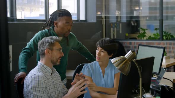 Business people discussing over computer in office 4k