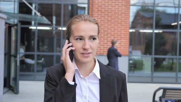 Walking Businesswoman Talking on Phone
