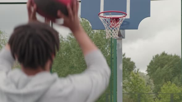 Man Shooting Ball into Hoop Outside