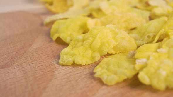 Dry uncooked corn flakes on a wooden textured surface