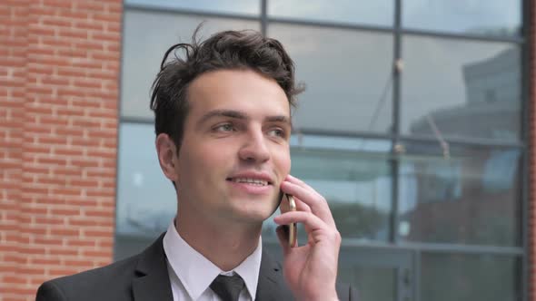 Businessman Talking on Phone Outside Office