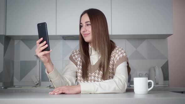 Young Woman Making a Video Chat in Smartphone at Home