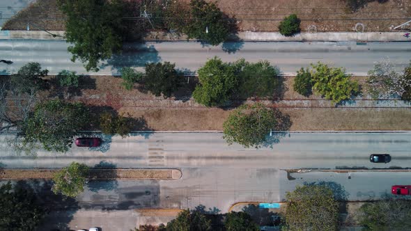 Cars at street through avenue with railroad at center