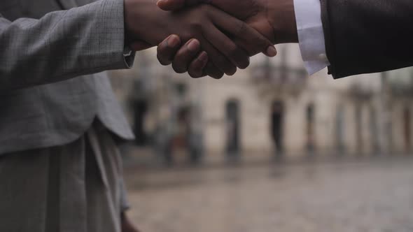 Close Up of Afro American Partners Shaking Hands Outdoors