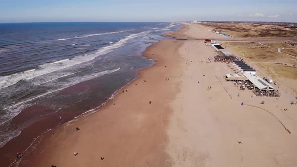 Aerial View Of Sea Waves Along Katwijk aan Zee Beach Coastline In South Holland. Dolly Back, Tilt Up