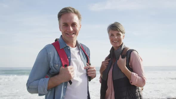 Portrait of Caucasian couple enjoying free time by the sea on sunny day