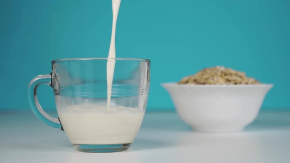 Pouring fresh milk into a glass on a blue background