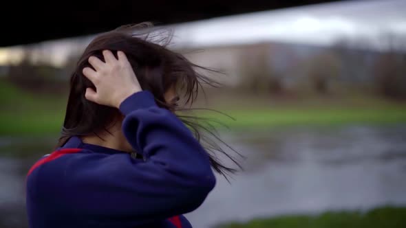 Portrait of a Brunette with Bright Lipstick on Her Lips and in a Blue Jumper on a Cloudy Day. She