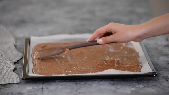 Spreading the Raw Chocolate Dough Over a Baking Sheet.