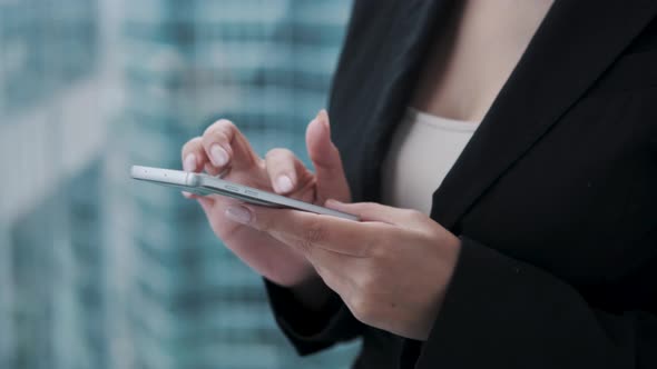 Closeup Portrait of a Young Business Woman with a Mobile Phone in Her Hands