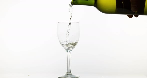 900122 White Wine being poured into Glass, against White Background, Slow motion 4K