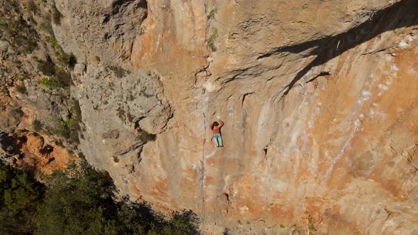 Aerial View From Drone of Strong Muscular Young Man Hanging on Rope and Descenting After Climbing on