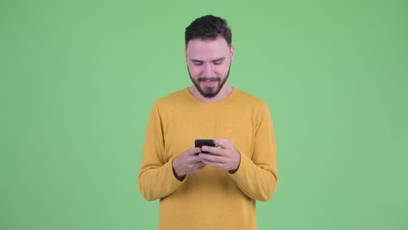 Happy Young Handsome Bearded Man Using Phone