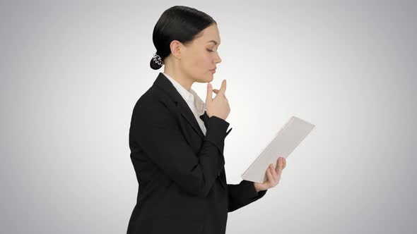 Businesswoman Using a Tablet Pad While Walking on Gradient Background