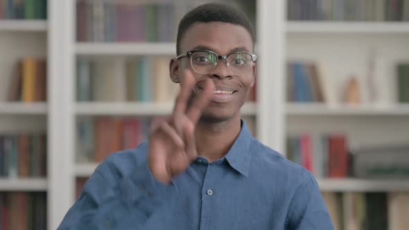 Young African Man Showing Victory Sign with Fingers