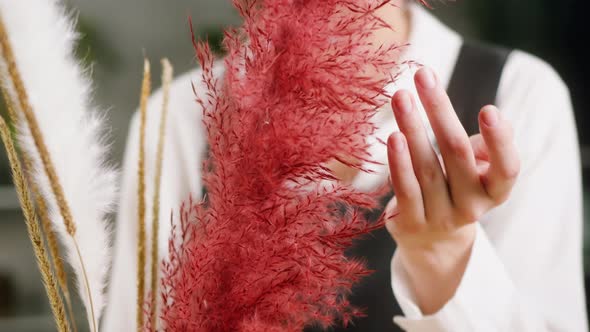 Young Florist Touching Red Dried Flowers Closeup