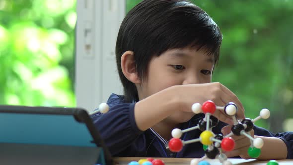 Asian Child Constructing Molecular Model  In Science Classroom