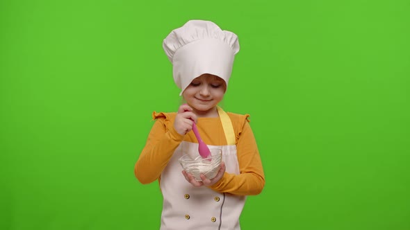 Child Girl Kid Dressed As Professional Cook Chef Stir Flour in Plate Smiling Showing Thumb Up
