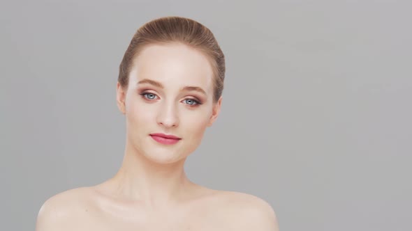 Studio portrait of young, beautiful and natural woman over grey background.