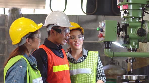Asian foreman training work to female trainees in the industrial factory