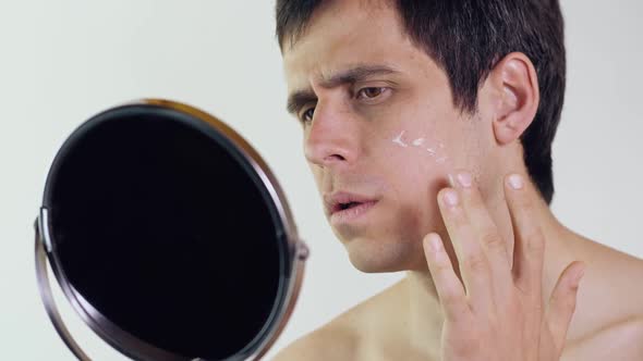 Man Applying Cream on Face