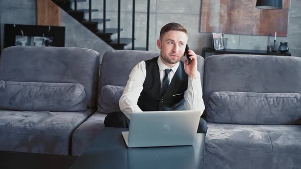 A Professional Sits in a Beautiful Dark Office in Front of a Laptop