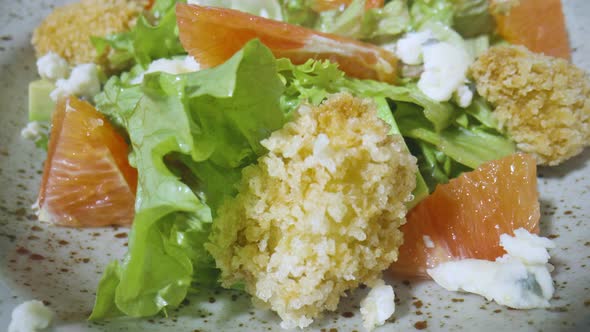 Salad with Grapefruit Green Lettuce Avocado Tuna Cheese on Gray Plate Rotating Close Up