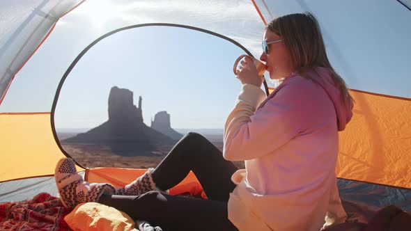 Happy Attractive Young Woman Drinking Warm Tea Camping in Canyon Mountains