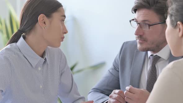 Cheerful Latin Businesswoman Talking to Colleagues