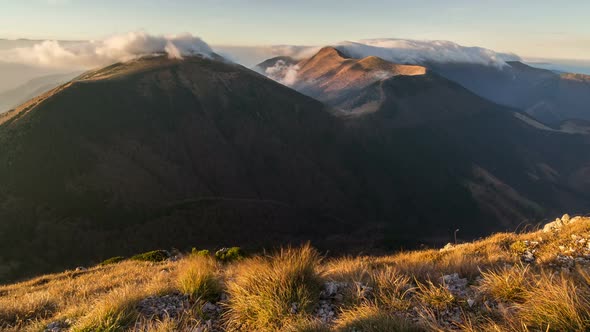 Morning Sunrise with Clouds Moving over Mountains Ridge in Autumn