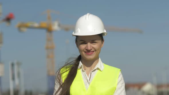 Girl Builder in Protective Clothes at Construction Site