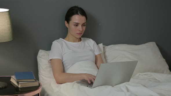 Professional Young Woman Working on Laptop in Bed 