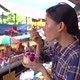 Asian woman eating coconut ice cream at Damnoen Saduak Floating Market - VideoHive Item for Sale