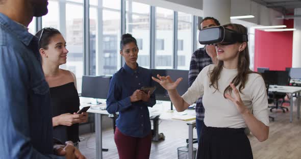 Diverse group of business colleagues using vr headset during meeting