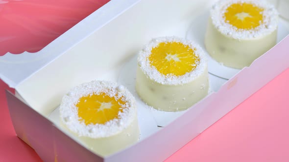 Small Cakes with Orange and Coconut Shavings in a Box