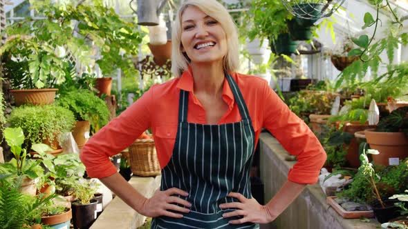 Happy mature woman smiling in greenhouse