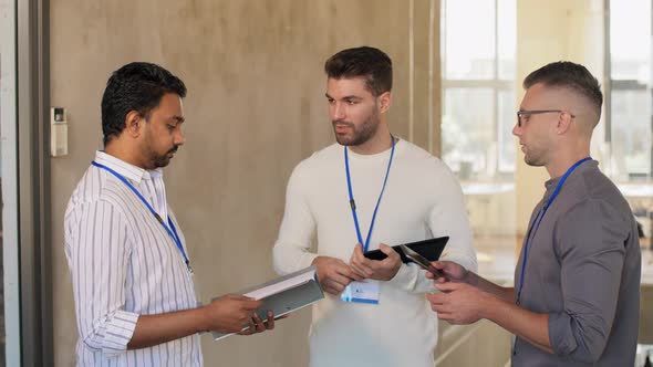 Businessmen with Name Tags Talking at Office