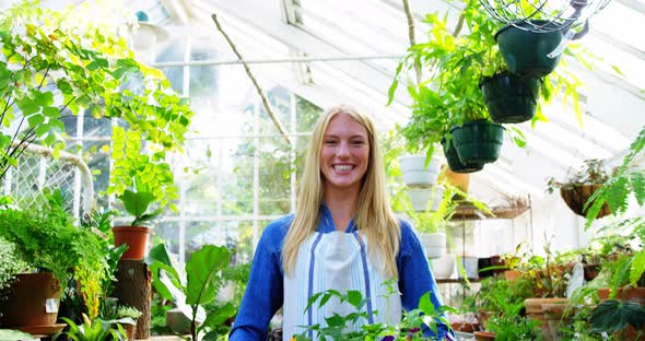 Portrait of beautiful woman carrying flower plant