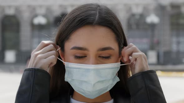 Happy Young Woman Taking Off Protective Face Mask Posing Outdoors