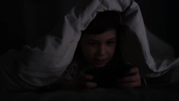 Boy Playing the Phone in the Dark
