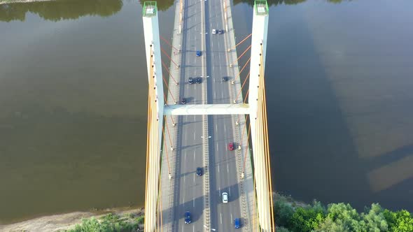 Aerial view of car traffic on modern bridge over river in city in summer day