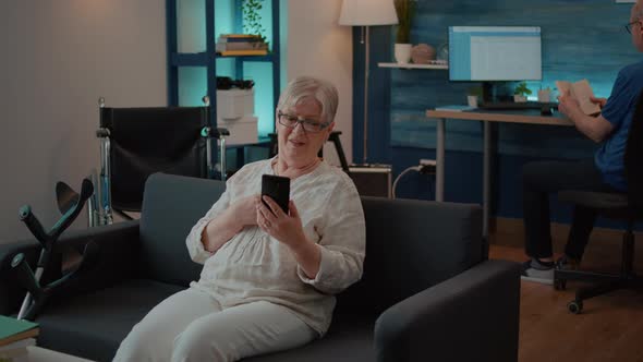 Senior Woman Waving at Video Call Webcam on Smartphone