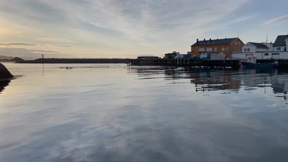 Forwarding shot from a boat of Kabelvag harbour, lofoten, Norway in the morning with sun setting ove