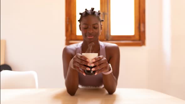Content black woman with healthy drink at home
